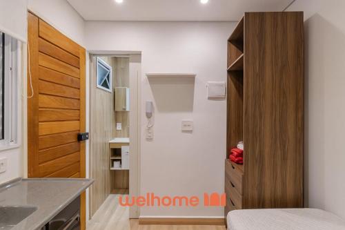 サンパウロにあるApto na Bela Vista Perto do Hospital Sirio Libanesの小さなキッチン(木製のドア付)が備わる客室です。