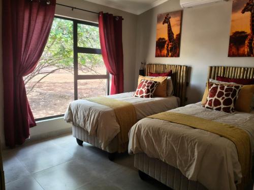 Eagle's Retreat في مارلوث بارك: سريرين في غرفة بها نافذة