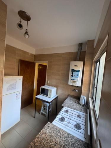 Departamentos Premium - 2 Ambientes - Excelente ubicación في ميرامار: مطبخ صغير مع ميكروويف وموقد