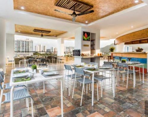 Un comedor con mesas y sillas y un bar. en SantaMartaTerrace, en Santa Marta