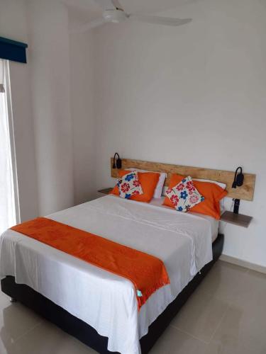 a bedroom with a large bed with orange pillows at SantaMartaTerrace in Santa Marta