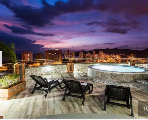 un patio en la azotea con piscina por la noche en SantaMartaTerrace, en Santa Marta