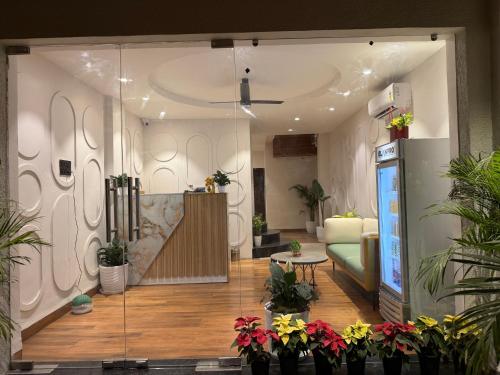 Hotel Aventus - by Urbantara في إندوري: غرفة معيشة بها أريكة وبعض النباتات