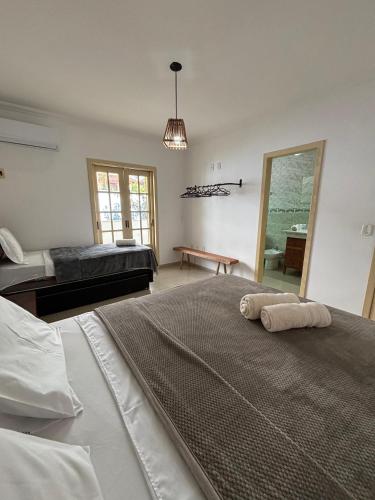 a large bedroom with two beds and a mirror at Villa das Araras Residence in Porto Seguro