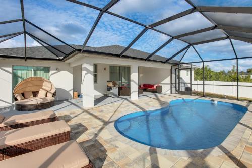 a swimming pool in a house with a glass roof at Furnished Lanai and Yard Comfy Lehigh Acres Getaway in Lehigh Acres