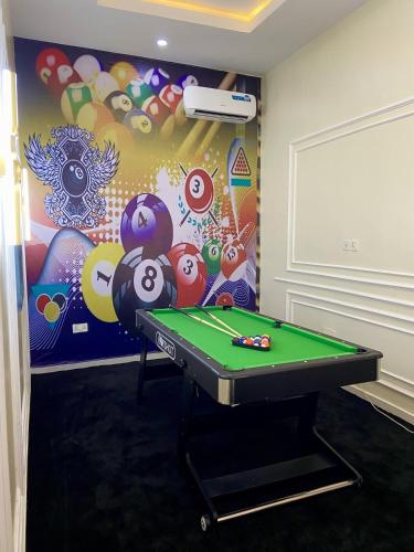 a room with a pool table in front of a wall at Bomo Apartment in Ikota