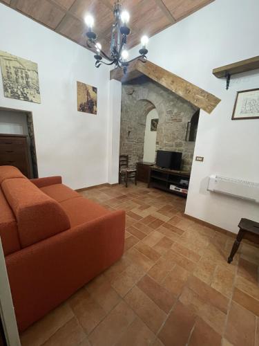 a living room with an orange couch and a fireplace at Appartamento Barone in Gubbio