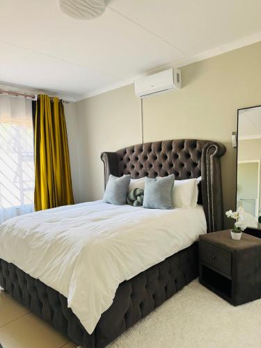 a bedroom with a large bed with a brown headboard at Graceful Getaway Air B&B in Rundu
