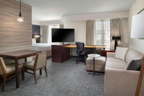 a hotel room with a bed and a living room at Residence Inn by Marriott New Orleans Metairie in Metairie