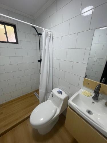 a white bathroom with a toilet and a sink at Habitación doble love con baño privado in Curicó