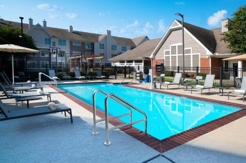 a swimming pool at a hotel with tables and chairs at Residence Inn by Marriott New Orleans Metairie in Metairie