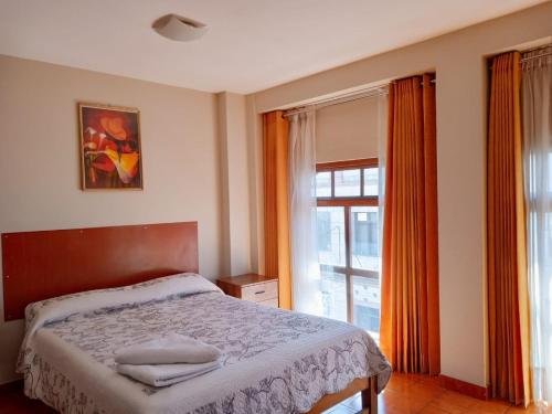 a bedroom with a bed and a large window at Casa de Isabel in Arequipa