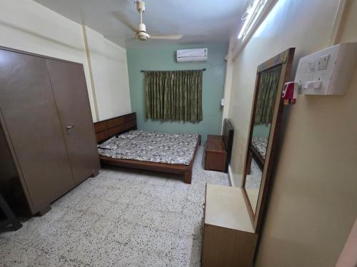 a small room with a bed and a mirror at Veenus Residency - Chinchwad in Chinchwad