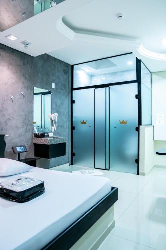 a bedroom with a large bed and a mirror at Prime Motel Piracicaba in Piracicaba