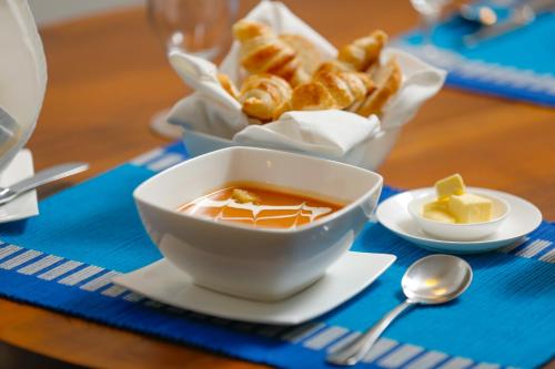 a table with a bowl of soup and a basket of bread at Viyana Boutique Hotel in Kandy