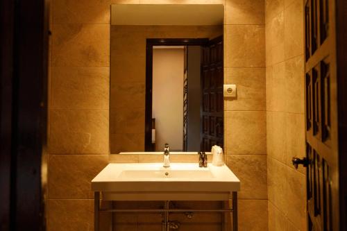 a bathroom with a sink and a mirror at Hotel Port 1730 in La Coma i la Pedra