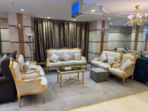 a living room with couches and chairs and a table at فندق ملتقى الايمان للضيافة السياحي in Al ‘Azīzīyah