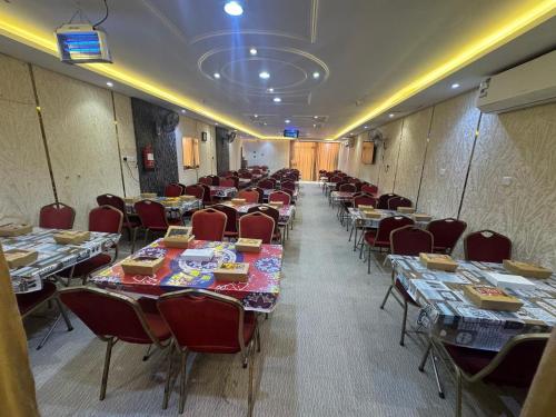 a conference room with tables and chairs in it at فندق ملتقى الايمان للضيافة السياحي in Al ‘Azīzīyah