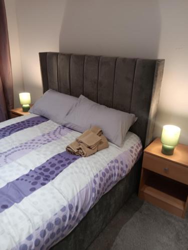 una bolsa en la parte superior de una cama con dos lámparas en High class accommodation, en Bury