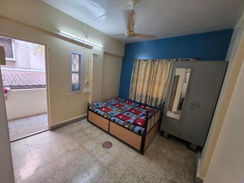 a bedroom with a bed in a room with a window at Veenus Residency - Chinchwad in Chinchwad