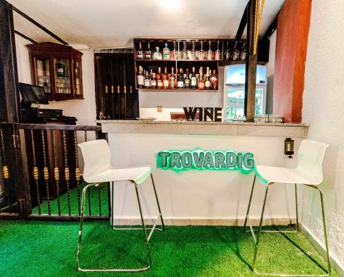 Un bar con dos sillas blancas y un cartel que dice viñedos. en The Mason by Trovardig Guzape, en Abuja