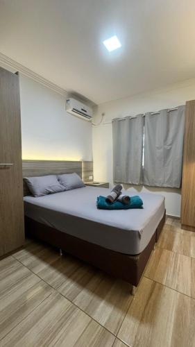 Casa Confortável em Localização Estratégica في فوز دو إيغواسو: غرفة نوم بسرير كبير عليها حذاء