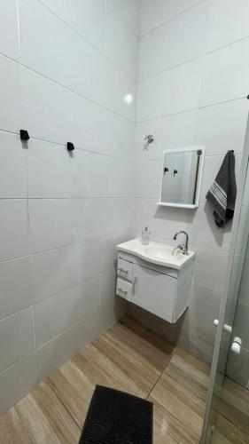 Casa Confortável em Localização Estratégica في فوز دو إيغواسو: حمام أبيض مع حوض ومرآة