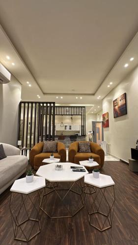 リヤドにあるشقة الفخامة - مدخل خاص ودخول ذاتيのテーブル2つとソファのあるリビングルーム
