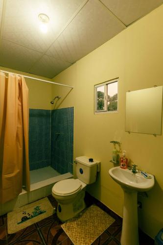 a bathroom with a toilet and a sink at Hotel Castillo Blanco in El Zonte