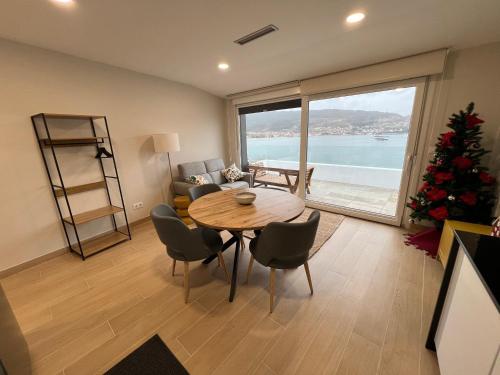 un soggiorno con tavolo e albero di Natale di Alborada Duplex a Moaña
