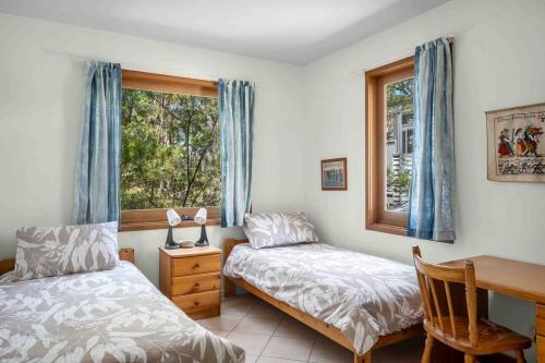 a bedroom with two beds and a desk and a window at Sweeds - Belle Escapes Jervis Bay in Vincentia