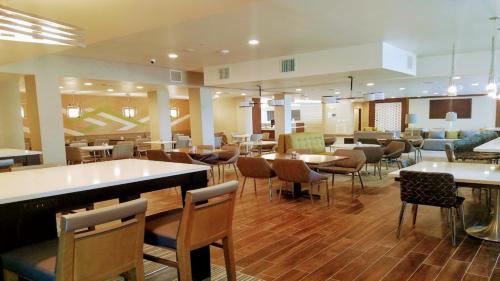 a restaurant with tables and chairs in a room at Holiday Inn & Suites Houston NW - Willowbrook by IHG in Houston