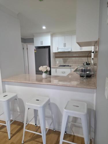 a kitchen with a counter with two stools and a counter top at Westcott in Rockbank