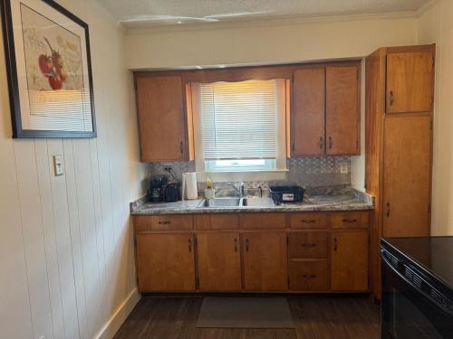Perfect for Travel Nurses Quiet في كلاركسبورغ: مطبخ مع خزائن خشبية ومغسلة ونافذة