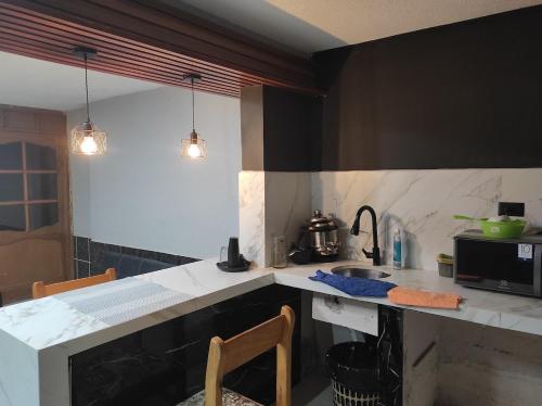 Una cocina con encimera con fregadero y estufa. en CASA ECUADOR Riobamba Chimborazo, en Riobamba