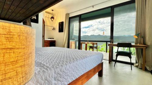 a bedroom with a bed and a large window at Searenity Octopus Cottage in Port Antonio