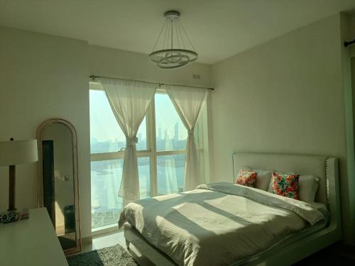 Panoramic B8 Sea View two bedroom apartment في أبوظبي: غرفة نوم بها سرير ونافذة كبيرة