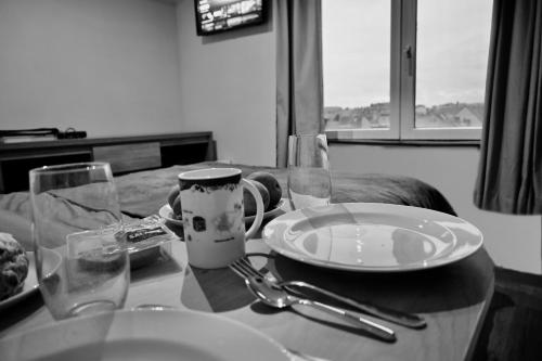 een tafel met een bord en een beker en glazen bij Bruges by the Beach in Blankenberge