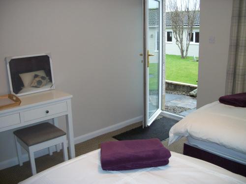 1 dormitorio con cama, escritorio y ventana en Premier Room, en Kelso