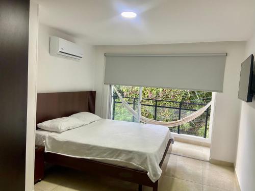 Un dormitorio pequeño con una cama y una ventana. en Casa San Sebastián, en San Gil