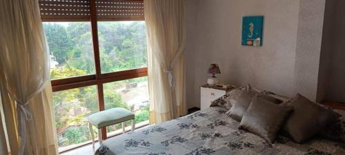 Departamento 3 ambientes a 2 cuadras del mar y Avenida Bunges في بينامار: غرفة نوم بها سرير ونافذة كبيرة