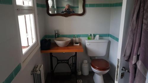 a woman taking a picture of a bathroom with a toilet at Habitación en Casa de Campo La Alborada in El Bolsón
