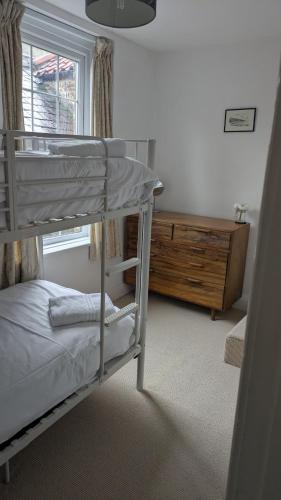 a bedroom with a bunk bed and a dresser at The Owlery Alnwick in Alnwick