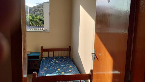 a small bedroom with a bed and a window at Quarto do Sol Relaxante - 150m da praia in Ubatuba
