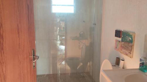 a bathroom with a shower and a toilet and a sink at Quarto do Sol Relaxante - 150m da praia in Ubatuba