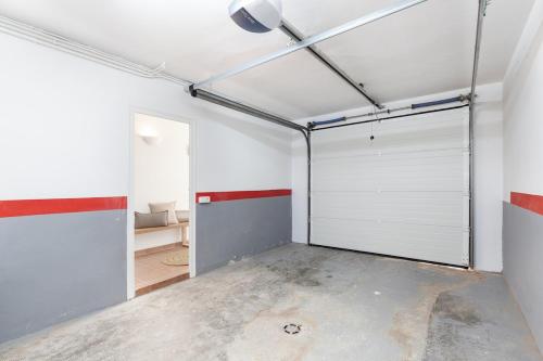 a garage with white garage doors in a room at Casa Rosari I - Jardín & Parking Privado in Vilassar de Mar