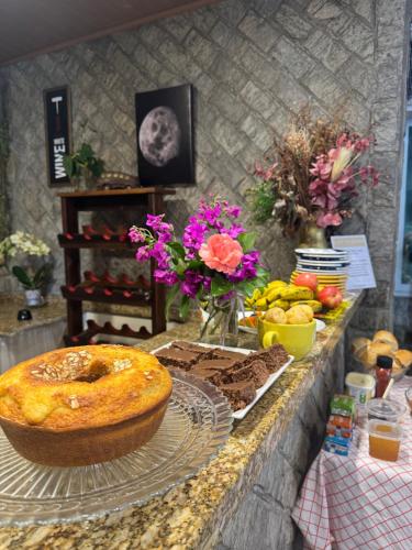 un tavolo con una torta e altro cibo sopra di Suíte Harry Potter - Pousada Castelo do Luar a Penha