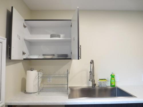 a kitchen with a sink and white cabinets at Entire Huge Basement! Fast Wifi! Private Entrance! in Salt Lake City