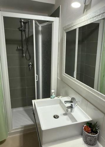 a bathroom with a sink and a shower and a mirror at La Medusa d'Ortigia in Syracuse