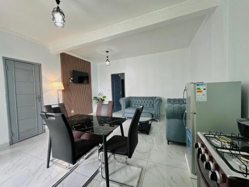 a kitchen and living room with a table and chairs at Loft Residence in Douala